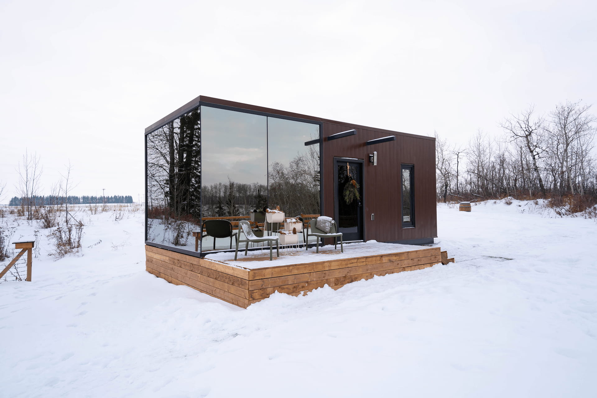 Modern glass-walled cabin in winter snow landscape